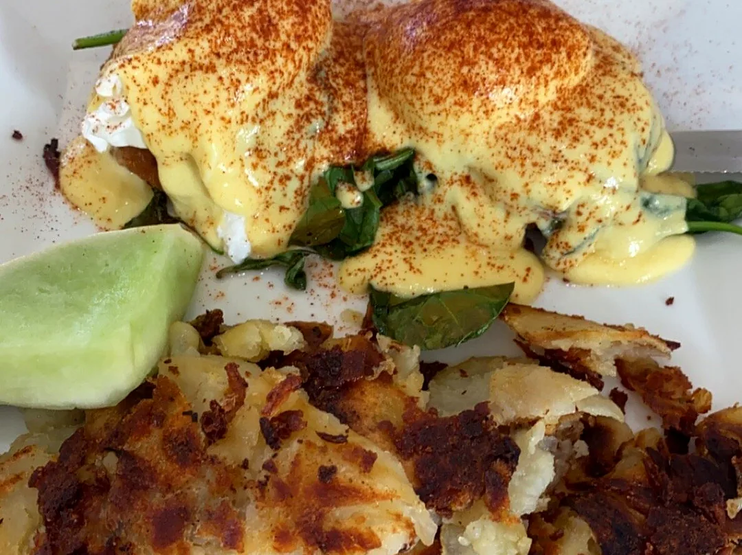 A benedict with spinach and hollandaise, potatoes and melon