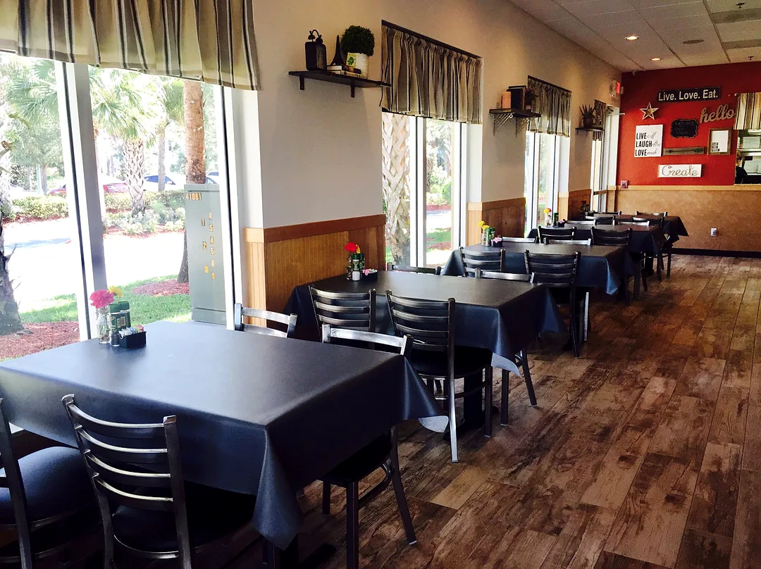 The Bonita Brunch dining room with dark tables and red accent walls